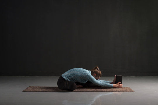 Woman Doing Yoga Training, Sitting In Janu Sirsasana, Head To Knee Forward Bend Pose, Asana For Stretching Shoulders, Spine. Studio Shot