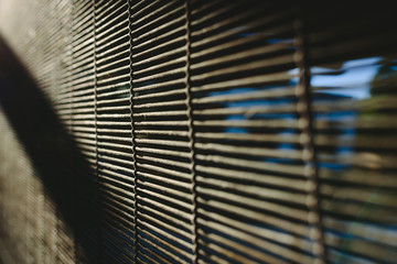 Background of natural materials with hard light at noon, blinds with wooden sheets.