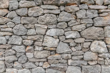Fototapeten Steinmauerbeschaffenheitshintergrund - graues Steinabstellgleis mit unterschiedlich großen Steinen © emotionpicture