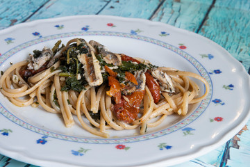 Linguine pasta with anchovies, black cabbage and dried tomatoes