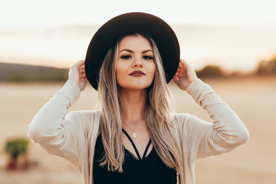 Portrait of beautiful woman wearing fedora hat outdoors