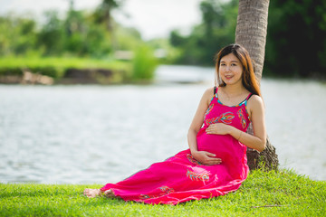 Portrait asian beautiful belly pregnant in public park