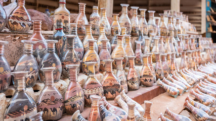 Colored souvenir bottles with sand and shapes of desert and camels, Petra, Jordan.