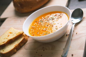 Closeup photo of seasonal autumn pumpkin soup and homemade pumpkin bread