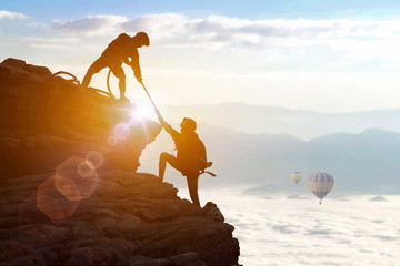 Climbing team are on the climb to the cliff,hiking and team work concept.    Mountaineer climbing a...