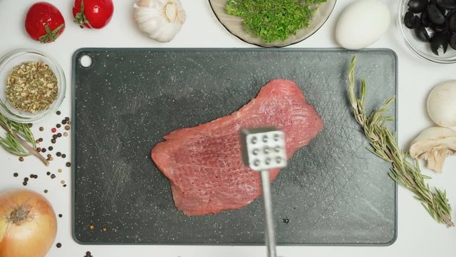 Video of meat and tenderizer in the kitchen