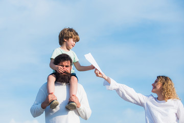 Child sits on the shoulders of his father. Retro hipster romantic couple in love with happy kid. Happy father giving shoulder ride on his shoulders.