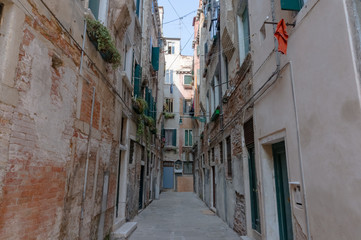 Fototapeta na wymiar Narrow Italian dead end street with old shabby buildings