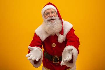 Santa Claus on yellow background with copy space. Presenting.