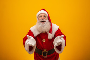 Santa Claus on yellow background with copy space. Presenting.