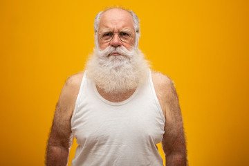 Old man with a long beard on a yellow background. Senior with full white beard. Old man with a long beard with sadness.