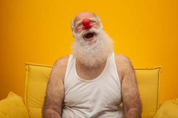 Happy old man with a red nose. All fools day. Elderly with red nose.