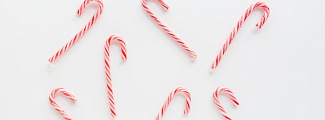 Christmas composition. lollipop canes on white. Minimal new year concept. Horizontal banner for web design. Greeting card, xmas celebration 2020. Flat lay, top view, copy space, mockup, template