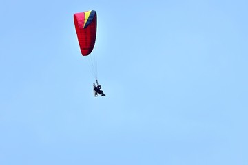 大空バックに優雅に飛ぶモーターパラグライダー