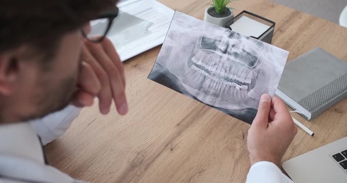 Orthodontist examining xray image at clinic