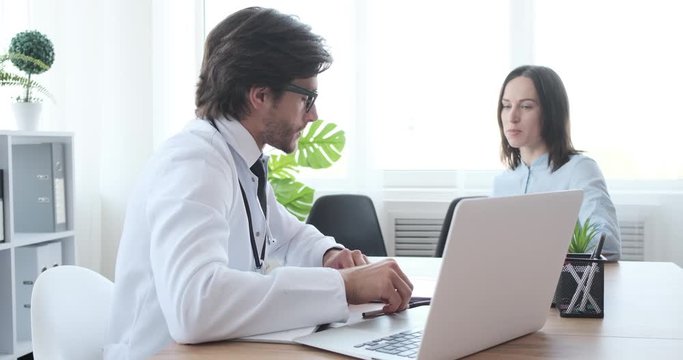Doctor speaking with woman patient about xray test result at clinic