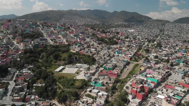 Aerial in colorful Ecatepec, Mexico. Drone flying bacwards over the houses