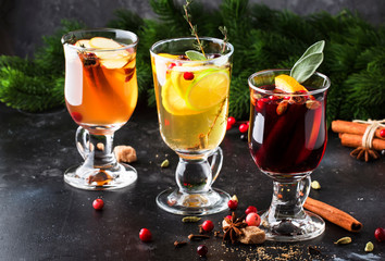 Mulled wine and mulled cider. Hot winter drinks and cocktails for christmas or new year's eve in glass mugs with spices and citrus fruit