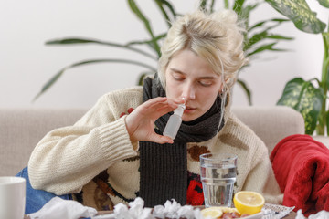 The girl in the sweater is sick lying on the couch. Colds and flu. The patient caught a cold,...
