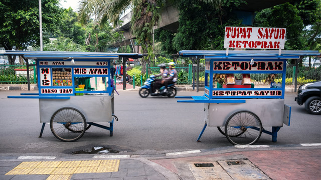 JAKARTA, INDONESIA - MAY 16, 2019_Colorful hawkers sell food by the street in Jakarta. Indonesian street food are usually cheap, offer a great variety of food of different tastes