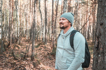 Naklejka na ściany i meble Hiker - man hiking in forest. Male hiker looking to the side walking in forest. Caucasian male model outdoors in nature. tinted image