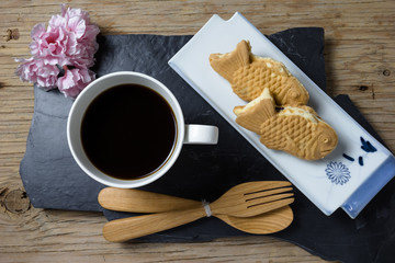 Taiyaki cakes with coffee on wood background