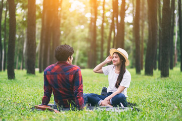 A young asian lover couple sitting together in the park