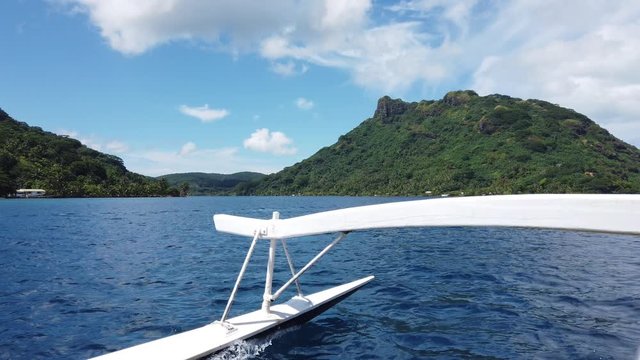 Tahiti Travel in French Polynesia in Outrigger boat in coral reef lagoon on island of Huahine. Cruise ship boat excursion tour. Outrigger boats are traditional and typical in French Polynesia.