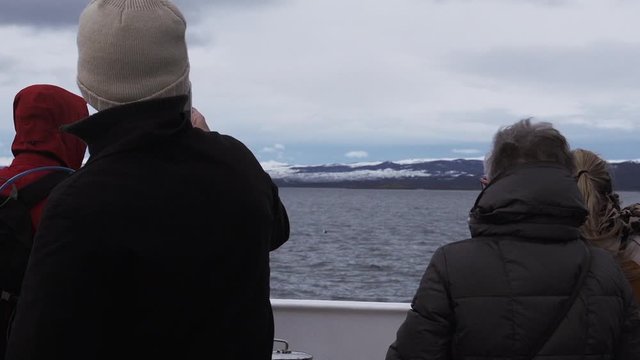 Group of Tourists on a Ship Navigating the Beagle Channel and Taking Pictures, in Tierra del Fuego, Argentina. 
