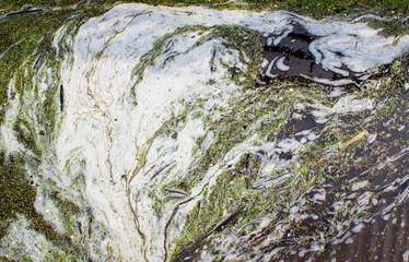 Texture of water with foam after the flood. Ecological catastrophy.