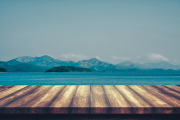 Wooden table with the sea and mountain backgrounds