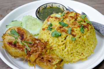 Chicken Biryani with cooked turmeric jasmine on wood background
