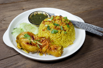 Chicken Biryani with cooked turmeric jasmine on wood background