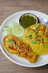 Chicken Biryani with cooked turmeric jasmine on wood background