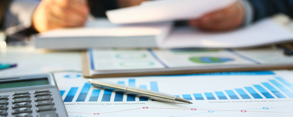 Financial statistics documents ball pen infographics at office table closeup. Internal Revenue...