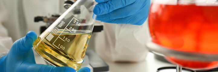 Male chemist hold test tube with yellow liquid biological research closeup. Conducts study urine...