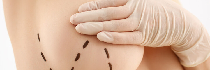 Female hand in gloves holding breast closeup on doctor mammology clinic reception. Mammary glands...