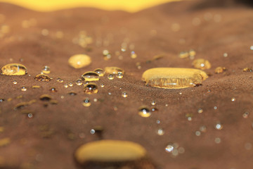 drops of water on the brown suede reflecting the yellow wall