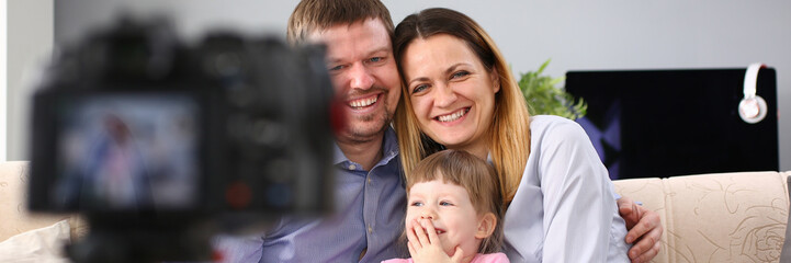 Young happy family sit on couch making photo session portrait looking at camera