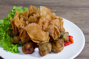 fried wonton or Toong Tong isolated on wood background