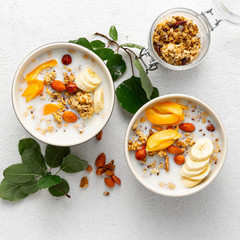 Granola fruit with milk, peanut butter in bowl. Healthy breakfast cereals top view