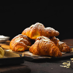 Breakfast croissant with chocolate on a dark stone background