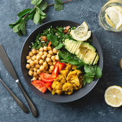 Buddha bowl Vegetarian healthy balanced food Aloo gobi, chickpeas, tomato, avocado, tabule salad spinach