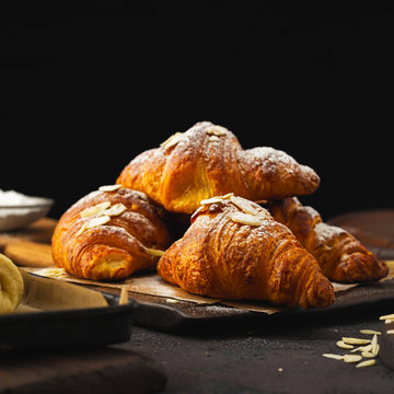 Breakfast croissant with chocolate on a dark stone background