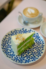 A slice of chocolate cake on the plate. Gula Melaka cake in green colour. Coffee cake tea time concept.