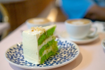A slice of chocolate cake on the plate. Gula Melaka cake in green colour. Coffee cake tea time concept.