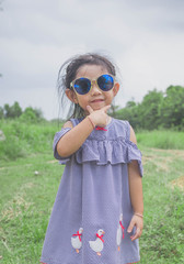 Cute little girl standing with sun glasses 