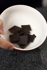 Pieces of broken chocolate bar in bowl