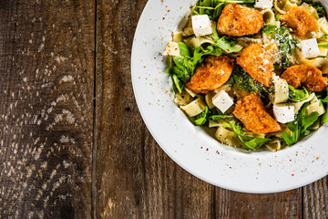 Pasta with chicken meat, feta cheese and rucola