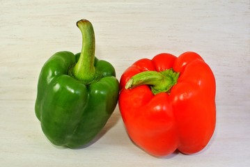 green and red bell pepper on a white wooden background